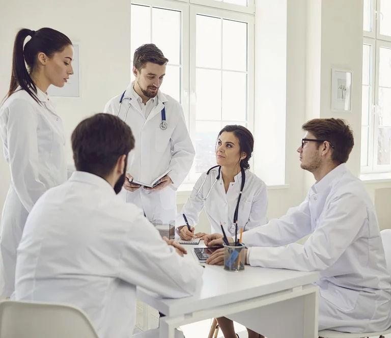 Group of doctors talking sitting at a table in the office of the hospital